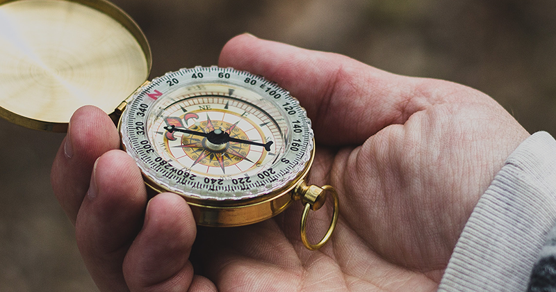 Hand holding a compass